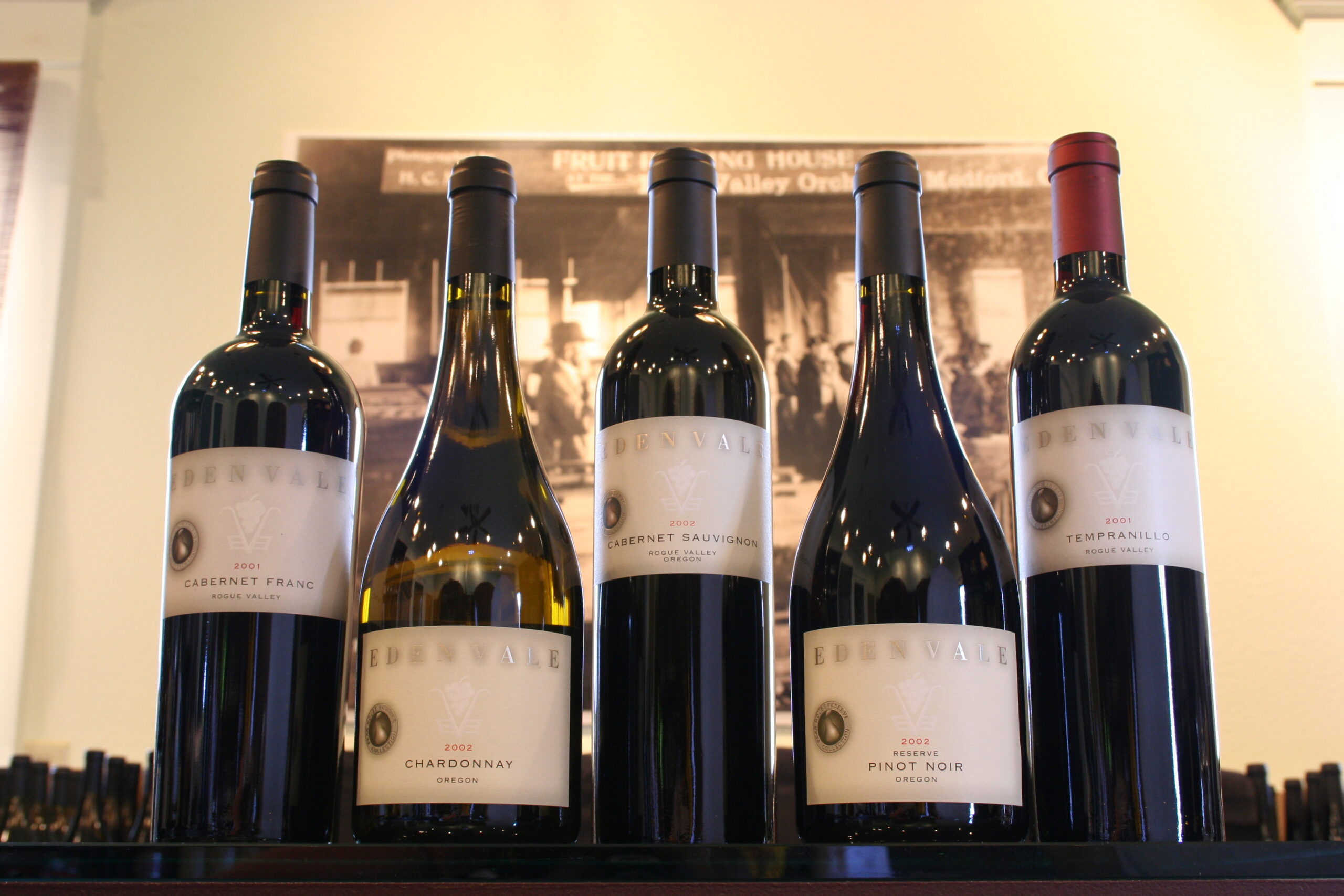close-up image of five wine bottles with edenvale labels in front of a historic black and white photograph on the wall